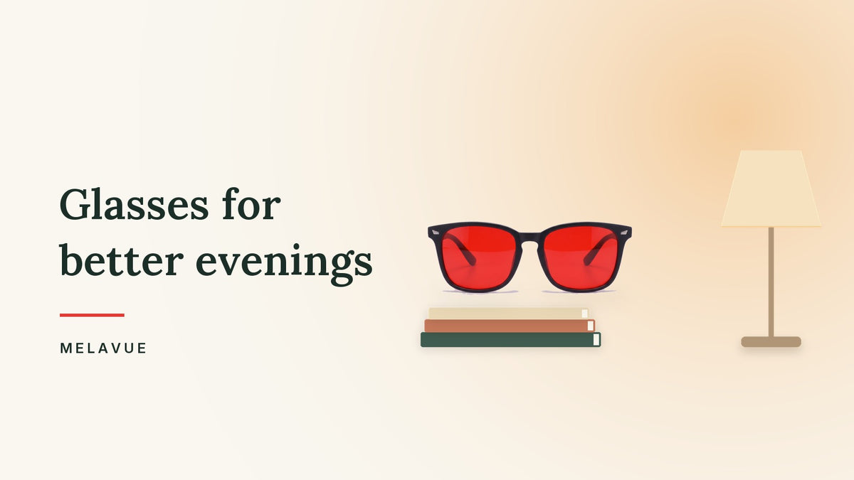 Melavue Midnight red lens glasses on a stack of books next to a dimmed lamp on a cream background